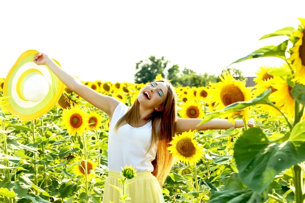 Schönes Mädchen mit Hut im Sonnenblumenfeld — Stockfoto