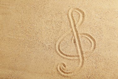 Violin key on a beach sand