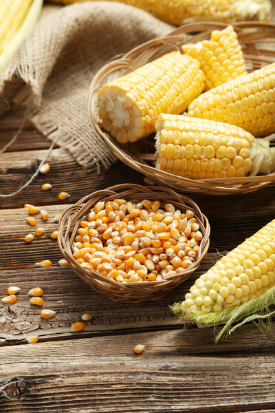 Corns in basket on wooden background