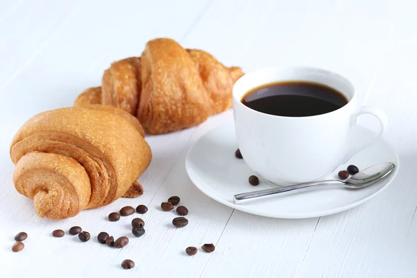 Croissants deliciosos com xícara de café — Fotografia de Stock