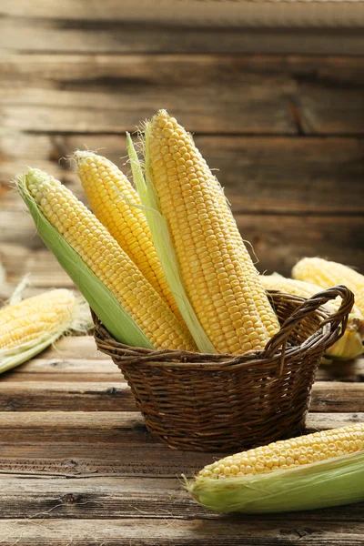 Corn in basket on wooden background — Stock Photo, Image