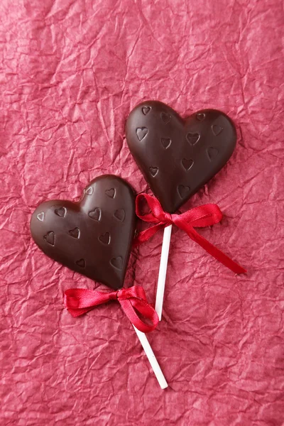 Chocolate hearts on paper background — Stock Photo, Image