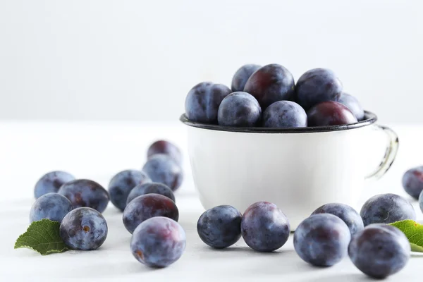 Fresh plums in cup — Stock Photo, Image