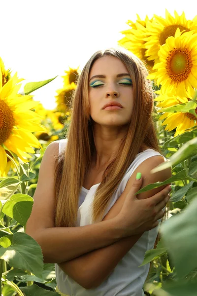 Прекрасная девушка на поле подсолнухов — стоковое фото
