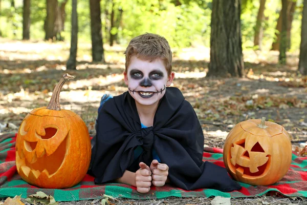 Little boy in halloween costume with pumpkin in the park, outdoo — Stock Photo, Image