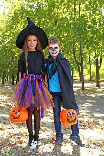 Menina bonita bruxa e menino com abóbora cesta no p — Fotografia de Stock