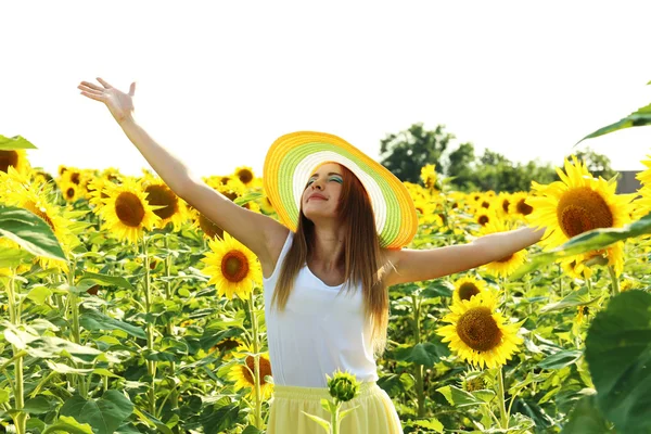 Ragazza con cappello in campo girasoli — Foto Stock