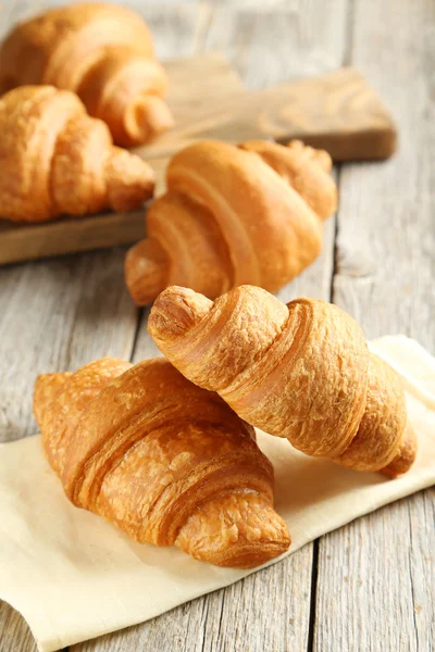 Chutné croissanty na dřevěném pozadí — Stock fotografie