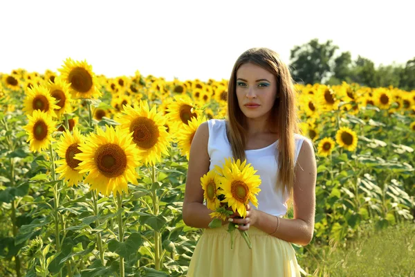 Hermosa chica en el campo de girasoles — Foto de Stock