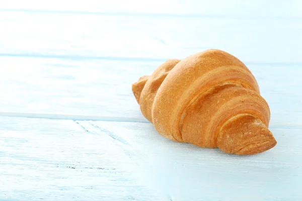 Ízletes croissant, fából készült háttér — Stock Fotó