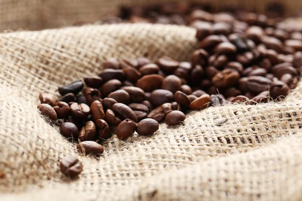 Rostade kaffebönor på en säck — Stockfoto