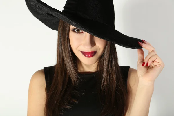 Brunette vrouw in zwarte jurk en hoed — Stockfoto