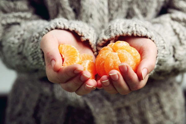 Жіночі руки тримають мандарини — стокове фото