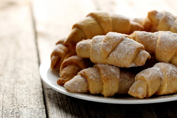 Čerstvé domácí croissanty na šedý dřevěný stůl — Stock fotografie