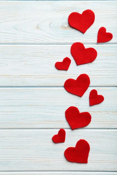 Rote Herzen auf einem blauen Holztisch — Stockfoto