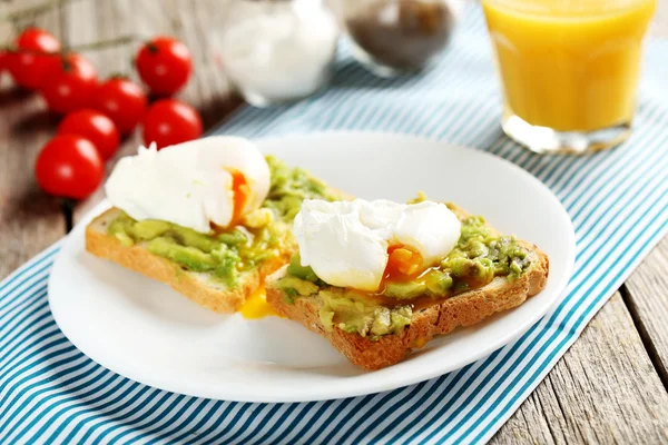 Pocherade ägg med avokado på rostat bröd — Stockfoto