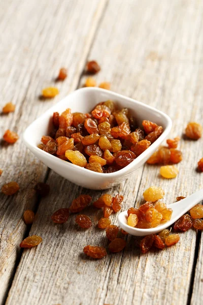 Dried raisins in the plate with spoon — Stock Photo, Image