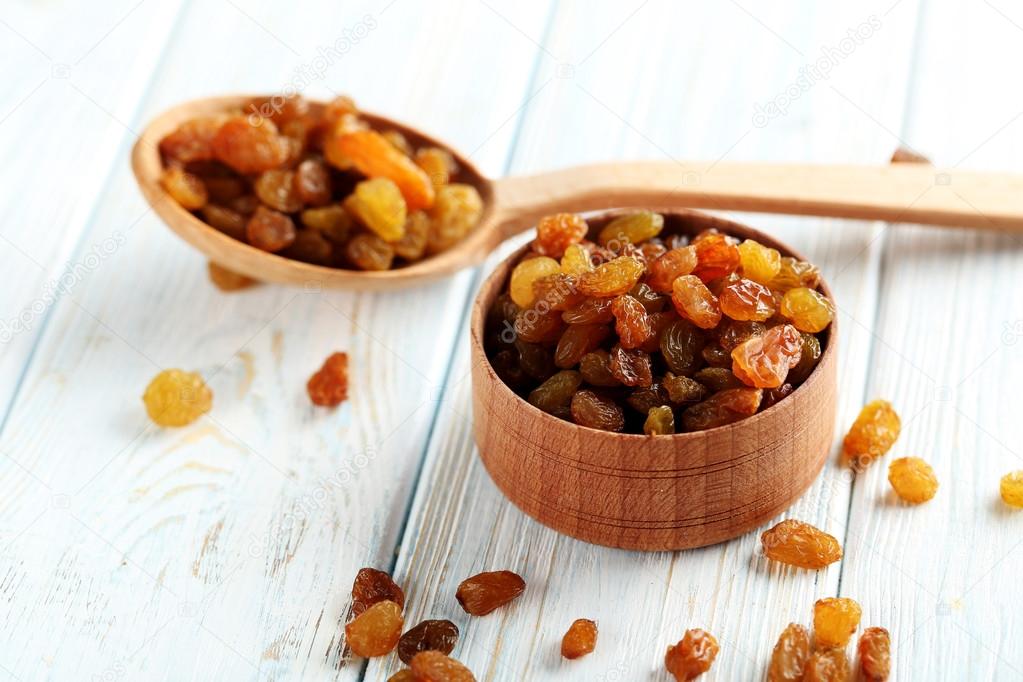 Dried raisins on a blue wooden table