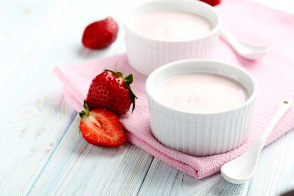 Jahodový jogurt v misce na modrý dřevěný stůl — Stock fotografie