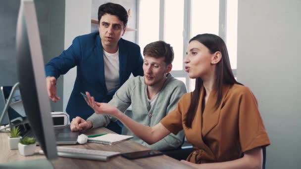 Een groep collega 's die werken aan een gezamenlijk project en een discussie hebben in de buurt van een computer. Teamwork concept — Stockvideo