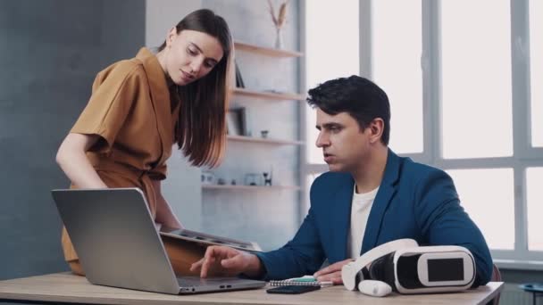 Teamwork in modern office, man and woman managers look at the laptop screen and talks — Stok video