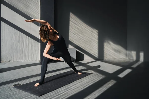 Giovane donna che pratica yoga posa in uno sfondo urbano nella giornata di sole Foto Stock