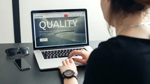 Shot of a young woman working with laptop, womans hands using notebook computer and smart phone, woman at her workplace using technology, flare light — Stock Photo, Image