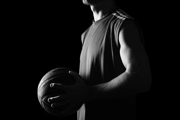 Basketbalspeler die bal geïsoleerd op zwarte achtergrond — Stockfoto