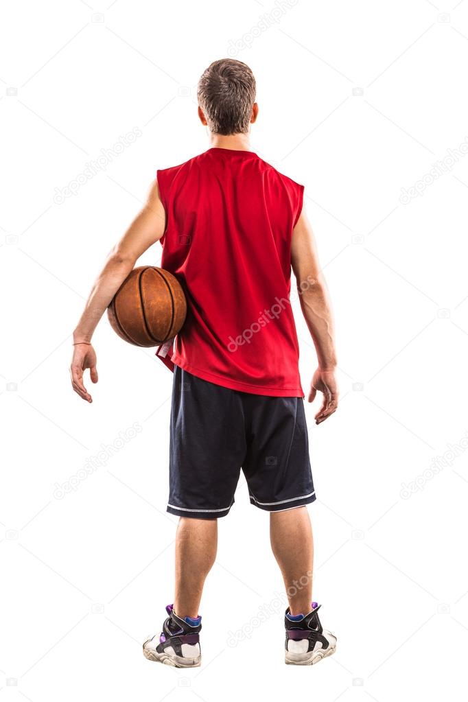 Basketball player standing with ball from the back isolated on white
