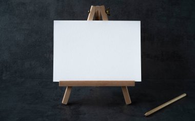 Beyaz tahtası olan ahşap sehpa, yazı için boşluk ve gri arka planda tahta kalem.