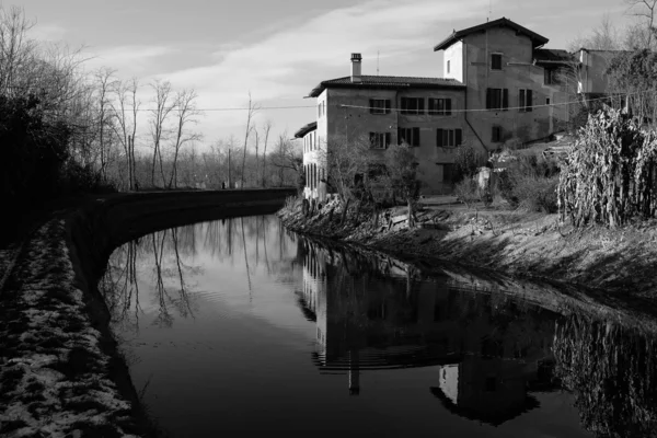 Dam med bygning refleksion over vand - Stock-foto