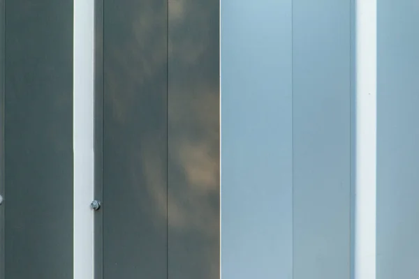 corner of shiny metal building wall paneling