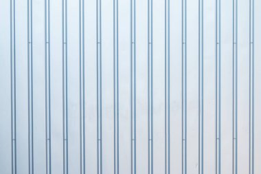 Parlak aynalı metal çizgili panellerden yapılmış bir duvar.