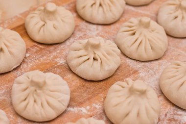 Raw khinkali sendeledi. Tahtaya un konmuş Gürcistan mutfağı.