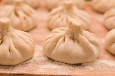 Çiğ khinkali kenar görünümü. Tahtaya un konmuş Gürcistan mutfağı.