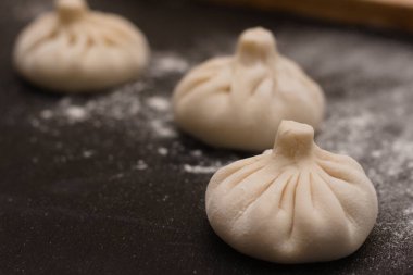 Masada un içinde üç çiğ Gürcü khinkali. Yan görünüm