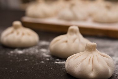 Masaya un serpiştirilmiş üç çiğ Gürcü khinkali. Yan görünüm