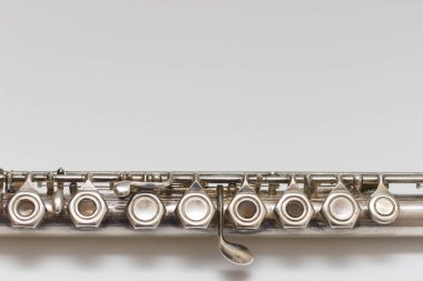 Beyaz arka planda yumuşak gölgeli tuşları olan gümüşi bir müzik aleti.