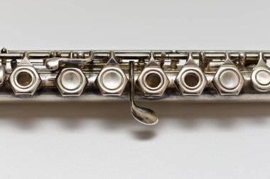 Gümüş flüt beyaz bir çarşafın üzerinde anahtarlar