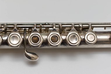 Beyaz arka planda yumuşak gölgeli tuşları olan gümüşi bir müzik aleti.