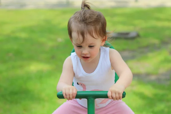 Liten Skrattar Förskolebarn Rider Gunga Lekplatsen Mot Bakgrund Grön Gräsmatta — Stockfoto