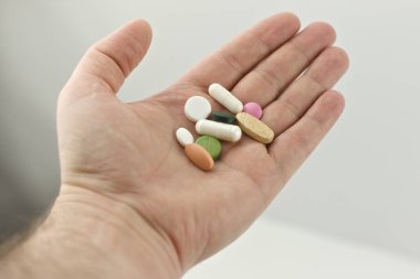 Elinde hap tutan bir adam.