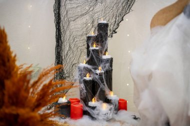 Cadılar Bayramı konsepti olarak el yapımı mumlar ve örümcek ağı. Sıcak ışık ve yaratıcı dekorasyon ile sıcak ve ürkütücü bir atmosfer..