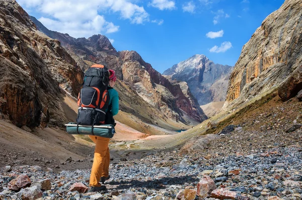 Chica con gran mochila está viajando en las montañas del ventilador — Foto de Stock