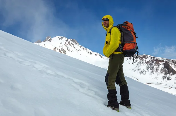 Homme grimpeur monte sur un volcan enneigé . — Photo