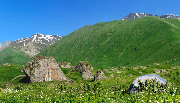 Graues Zelt im Gras vor dem Hintergrund von Bergen und Felsen — Stockfoto
