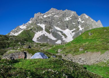 gri arka plan dağlar ve kayalar üzerinde çim çadırda
