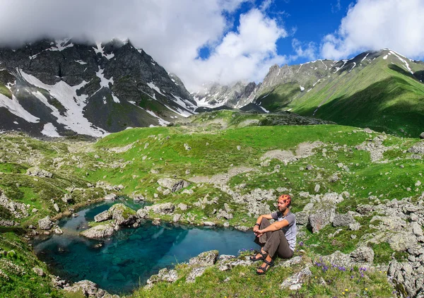 Joven hombre admira el lago de montaña . —  Fotos de Stock