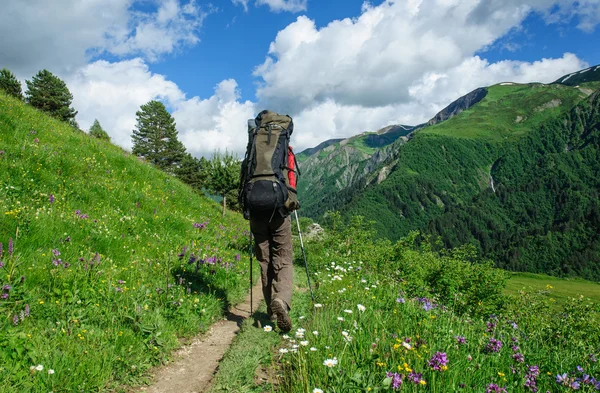 Joven turista descansando en la cima con vistas al valle — Foto de Stock