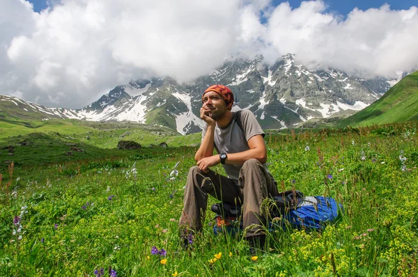 Joven turista descansando en la cima con vistas al valle — Foto de Stock